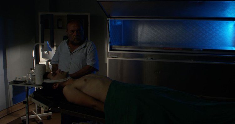 Коронер осматривает труп