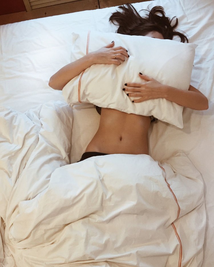 Брюнетка лежа в кровати