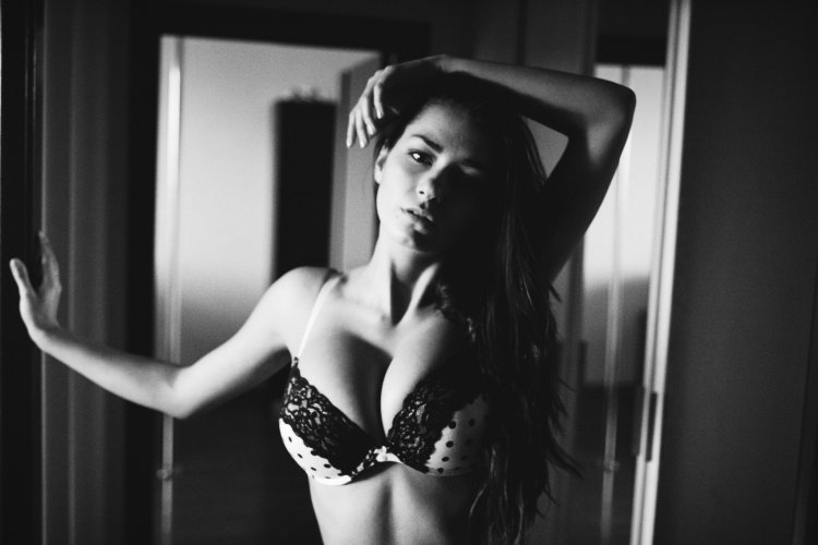 Расстегивает бюстгальтер