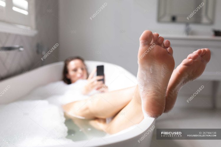 Женские босые стопы в ванной
