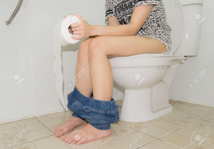 Девушка в платье сидит на унитазе