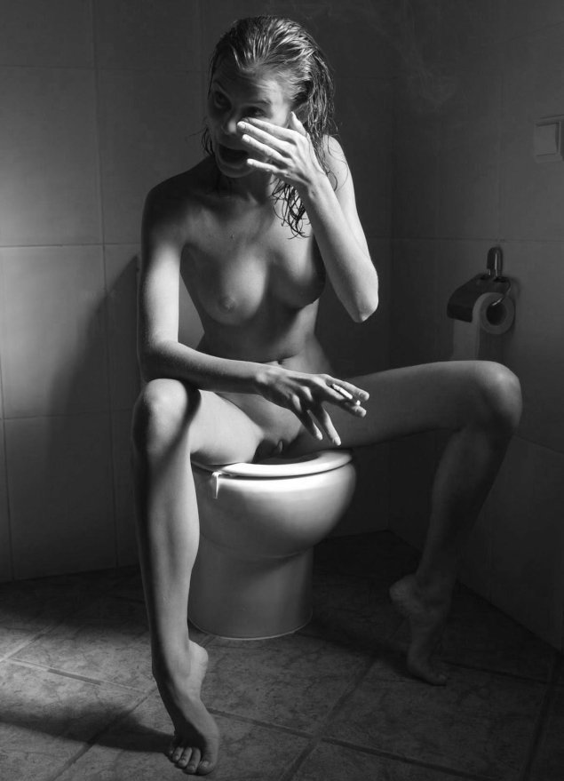 Девушка эротично сидит на унитазе